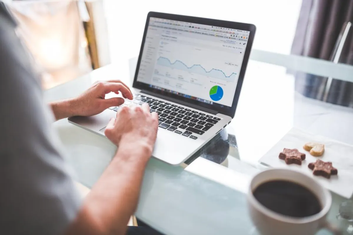 Personne qui consulte les statistiques de visites d'un site sur un ordinateur portable